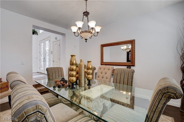 dining area with an inviting chandelier and hardwood / wood-style flooring