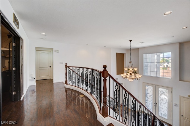 hall featuring french doors, a notable chandelier, and dark hardwood / wood-style flooring