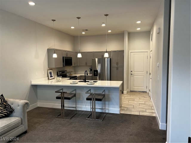 kitchen featuring appliances with stainless steel finishes, kitchen peninsula, sink, and light colored carpet