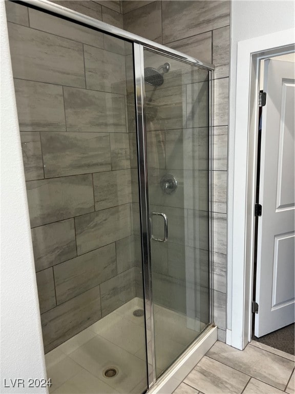 bathroom with tile patterned flooring and a shower with door