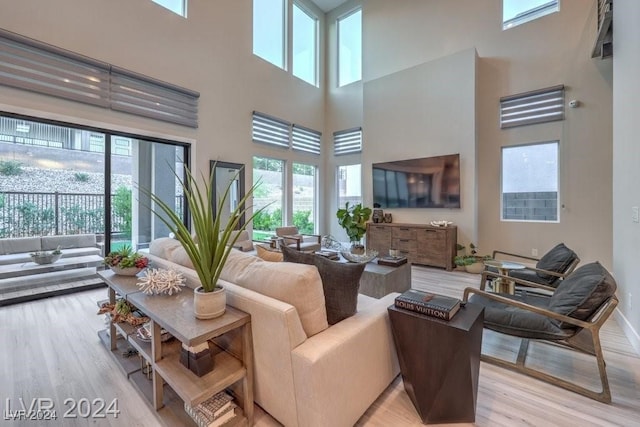 living room featuring light hardwood / wood-style flooring and a high ceiling