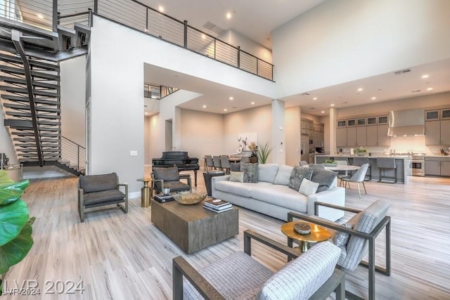 living room featuring a high ceiling and light hardwood / wood-style floors