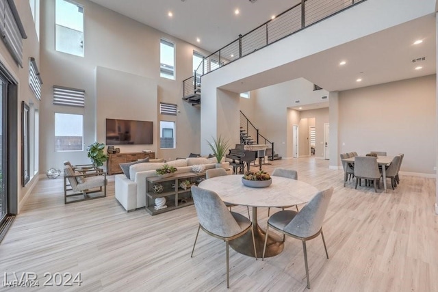 dining area with a high ceiling and light wood-type flooring