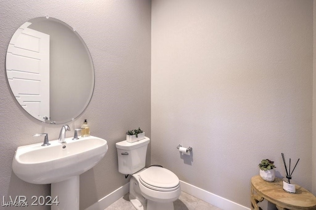 bathroom featuring tile patterned flooring, toilet, and sink