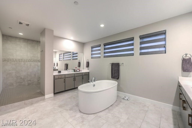 bathroom with independent shower and bath, vanity, and tile patterned floors