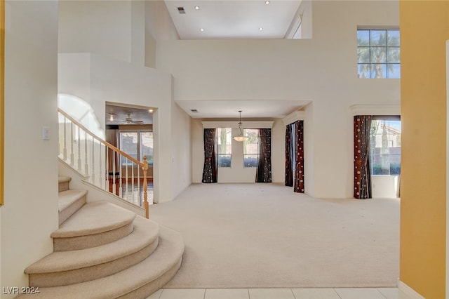 interior space featuring a wealth of natural light, carpet, and a high ceiling