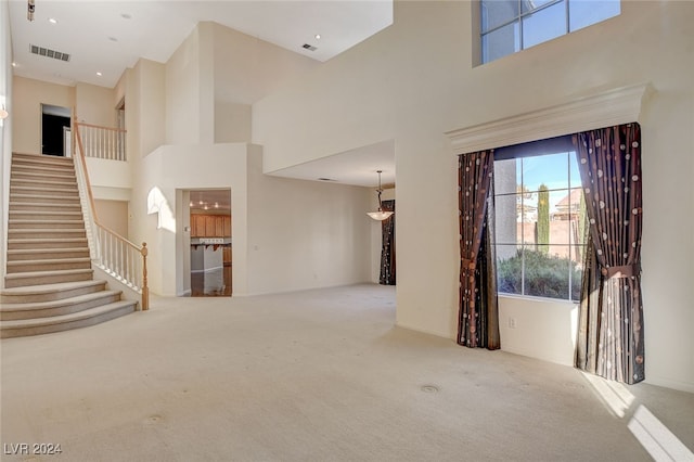 foyer entrance featuring light carpet and a high ceiling