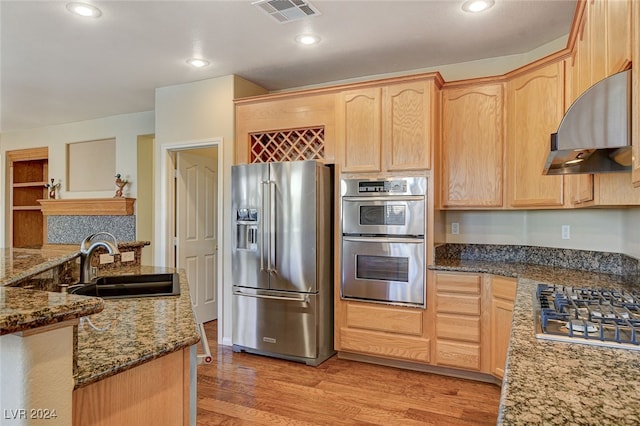 kitchen featuring sink, stainless steel appliances, light hardwood / wood-style floors, light brown cabinetry, and exhaust hood