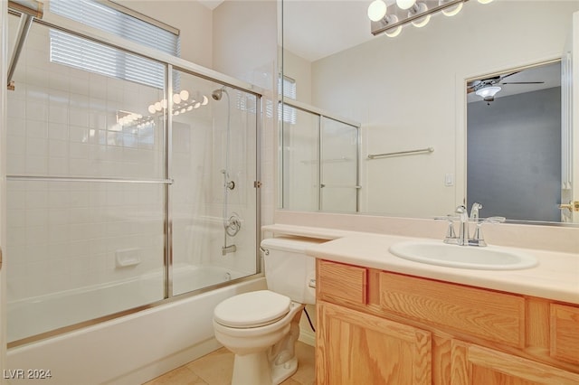 full bathroom with combined bath / shower with glass door, tile patterned floors, vanity, ceiling fan, and toilet