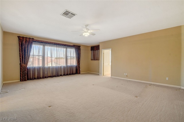 unfurnished room with ceiling fan and light carpet