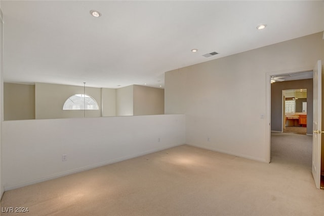 spare room featuring light carpet and ceiling fan