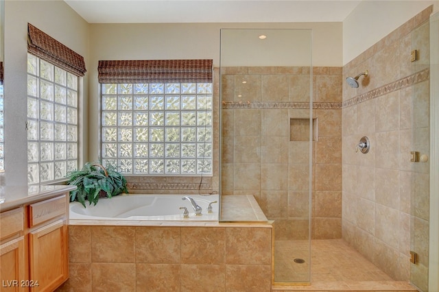 bathroom featuring vanity and independent shower and bath