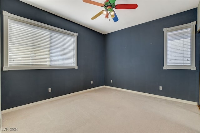 unfurnished room featuring ceiling fan and carpet