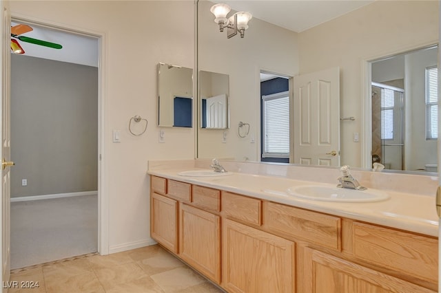 bathroom with a shower with door, tile patterned flooring, vanity, and a chandelier