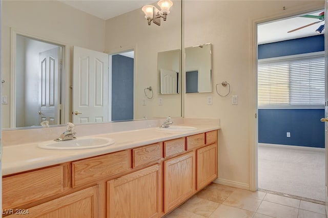 bathroom with ceiling fan with notable chandelier, vanity, and tile patterned floors