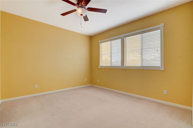 spare room with ceiling fan and light carpet