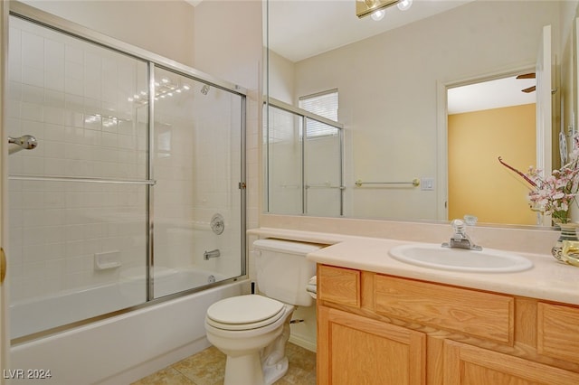 full bathroom with combined bath / shower with glass door, tile patterned floors, vanity, and toilet