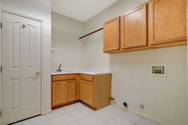 washroom featuring cabinets, washer hookup, sink, light tile patterned floors, and hookup for a gas dryer