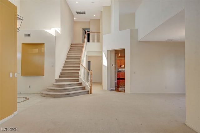 stairs with carpet and a high ceiling