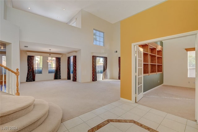 interior space featuring carpet, a high ceiling, and plenty of natural light