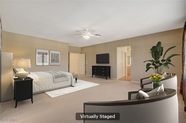 bedroom with ceiling fan, light colored carpet, and ensuite bathroom