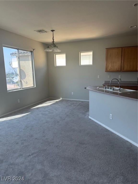 kitchen with hanging light fixtures, carpet, and sink