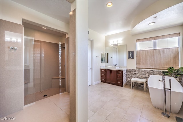 bathroom featuring vanity, shower with separate bathtub, and tile patterned flooring