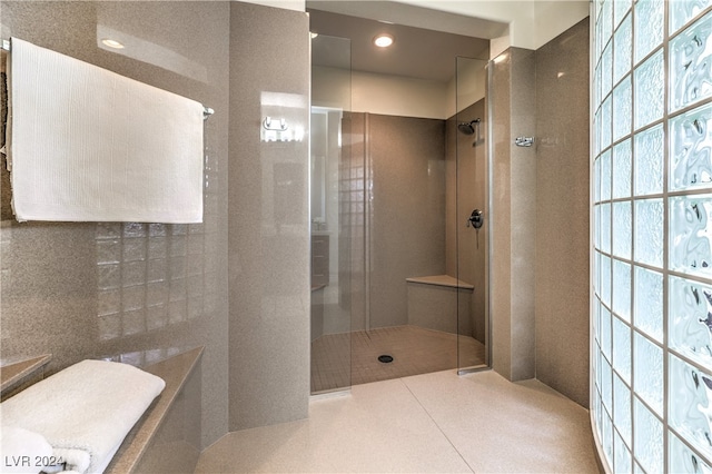 bathroom featuring tile walls and a tile shower