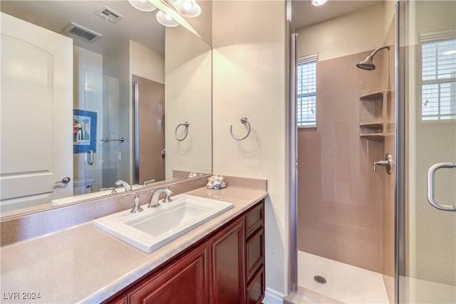 bathroom featuring vanity, toilet, and an enclosed shower