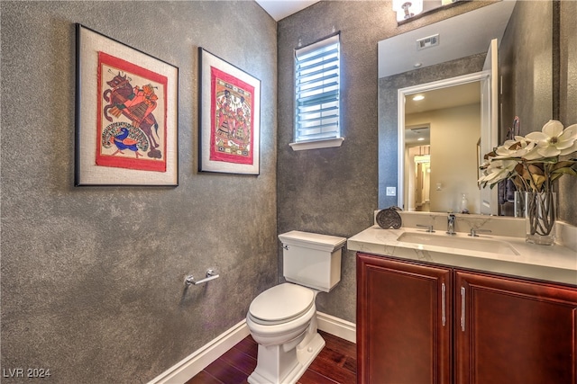 bathroom featuring toilet, hardwood / wood-style floors, and vanity