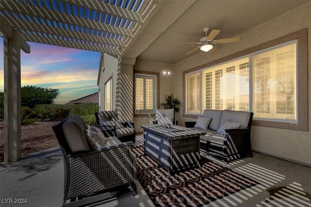 patio terrace at dusk featuring an outdoor living space, ceiling fan, and a pergola