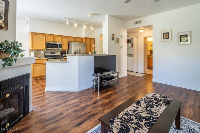 kitchen with tasteful backsplash, ceiling fan, stainless steel appliances, light stone countertops, and dark wood-type flooring