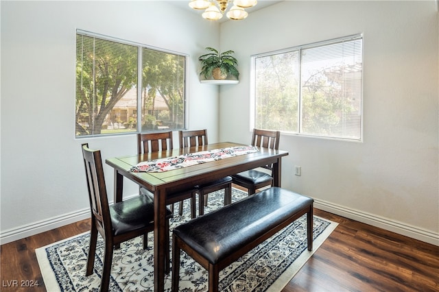 dining space with dark hardwood / wood-style flooring and a chandelier