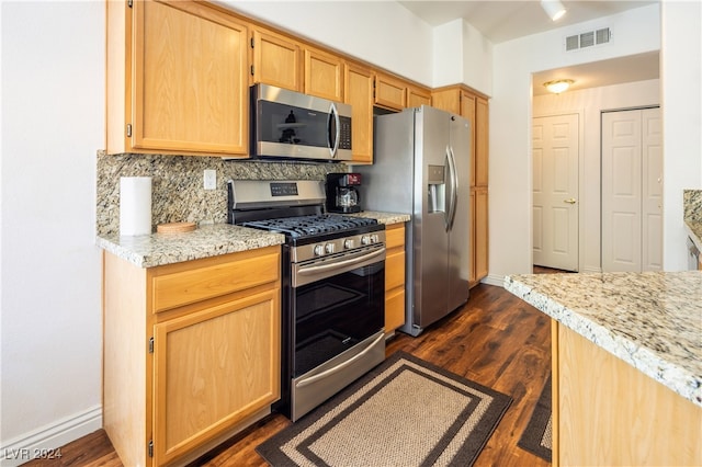 kitchen with light brown cabinetry, appliances with stainless steel finishes, dark hardwood / wood-style flooring, light stone countertops, and decorative backsplash