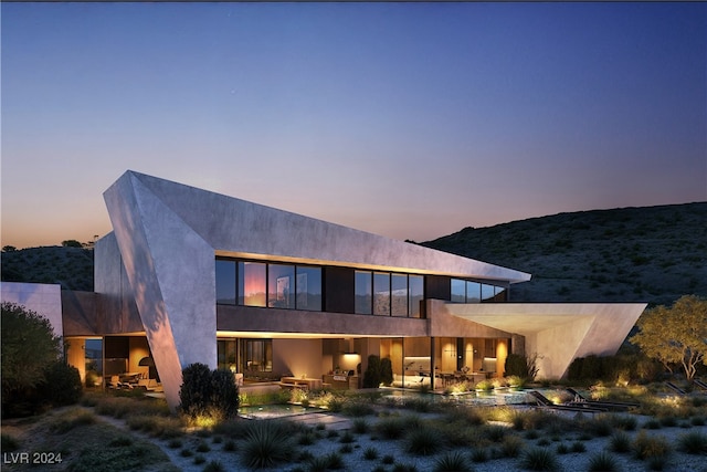 back house at dusk featuring a mountain view