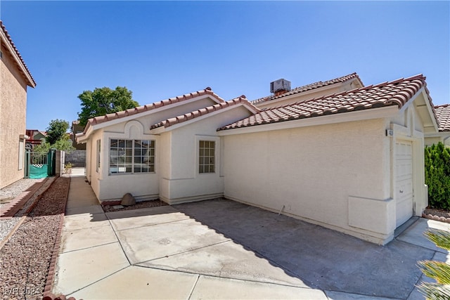 rear view of property with a garage and a patio