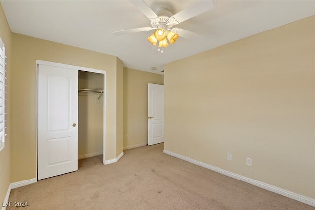 unfurnished bedroom featuring light carpet, a closet, and ceiling fan