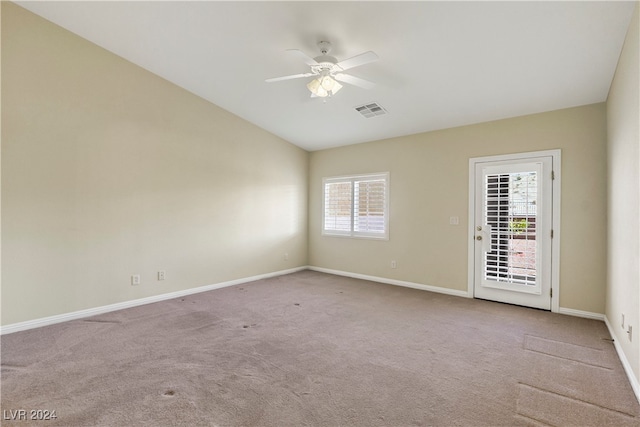 empty room with ceiling fan, light colored carpet, and vaulted ceiling