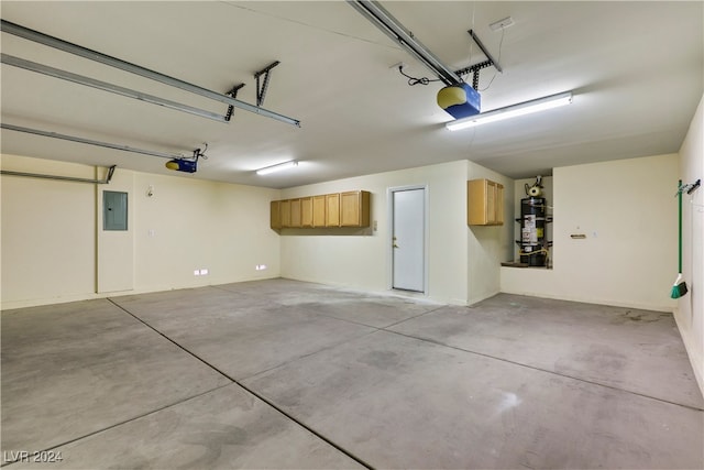 garage featuring water heater, electric panel, and a garage door opener