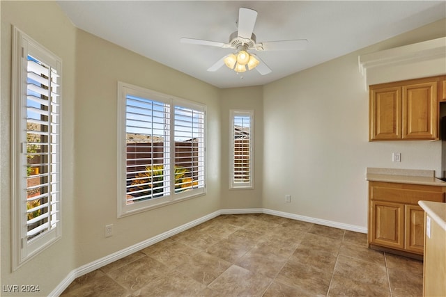 unfurnished dining area with ceiling fan and light tile patterned floors