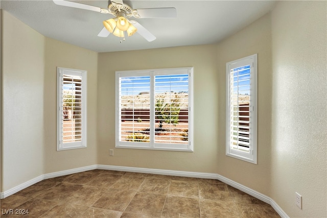 empty room with ceiling fan and a healthy amount of sunlight