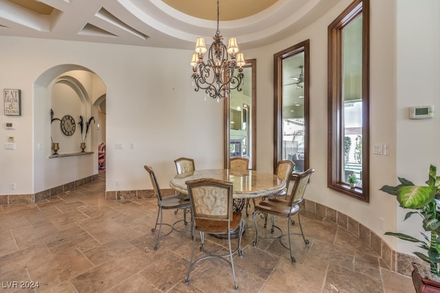 dining room with coffered ceiling, a raised ceiling, and an inviting chandelier