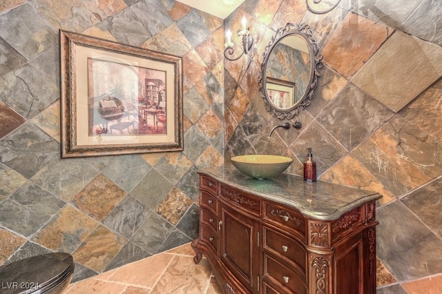 bathroom featuring vanity, tile walls, and toilet