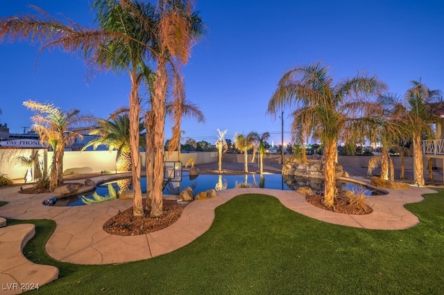 yard at dusk with a fenced in pool and a patio