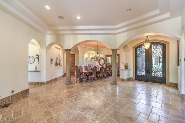 foyer entrance featuring a chandelier, french doors, and crown molding