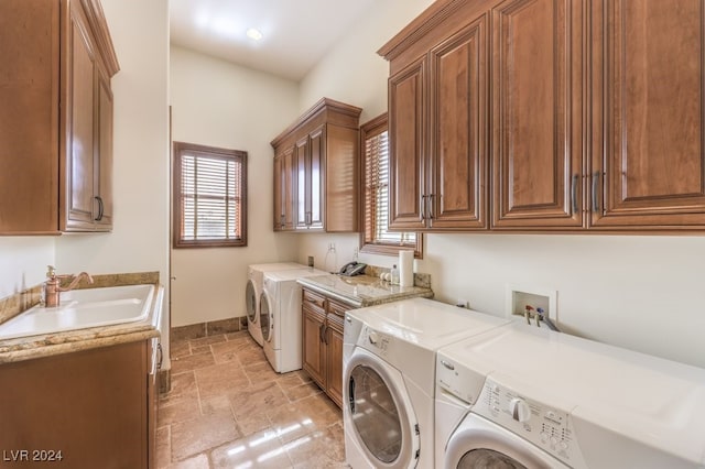 clothes washing area with cabinets, separate washer and dryer, and sink