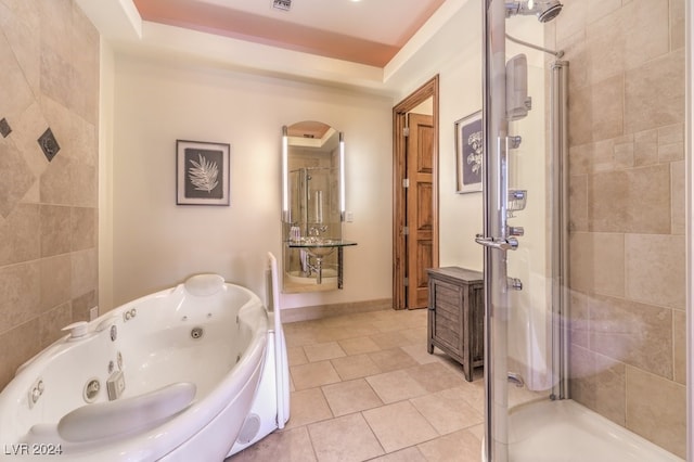 bathroom with tile patterned flooring, shower with separate bathtub, and a raised ceiling