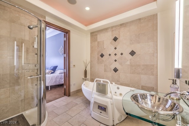 bathroom featuring tile patterned flooring, a raised ceiling, a shower with shower door, and sink