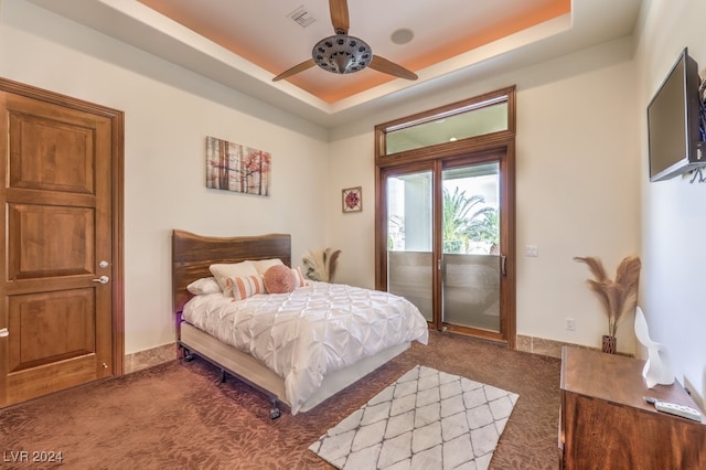 bedroom with carpet flooring, ceiling fan, a tray ceiling, and access to outside