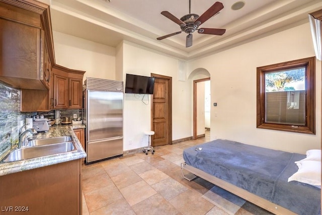 bedroom featuring a tray ceiling, built in fridge, sink, and ceiling fan